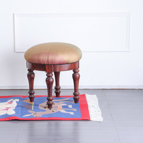 Handwoven cotton rug with camel and rabbit motifs styled in a decorative corner adding colour and artisan charm