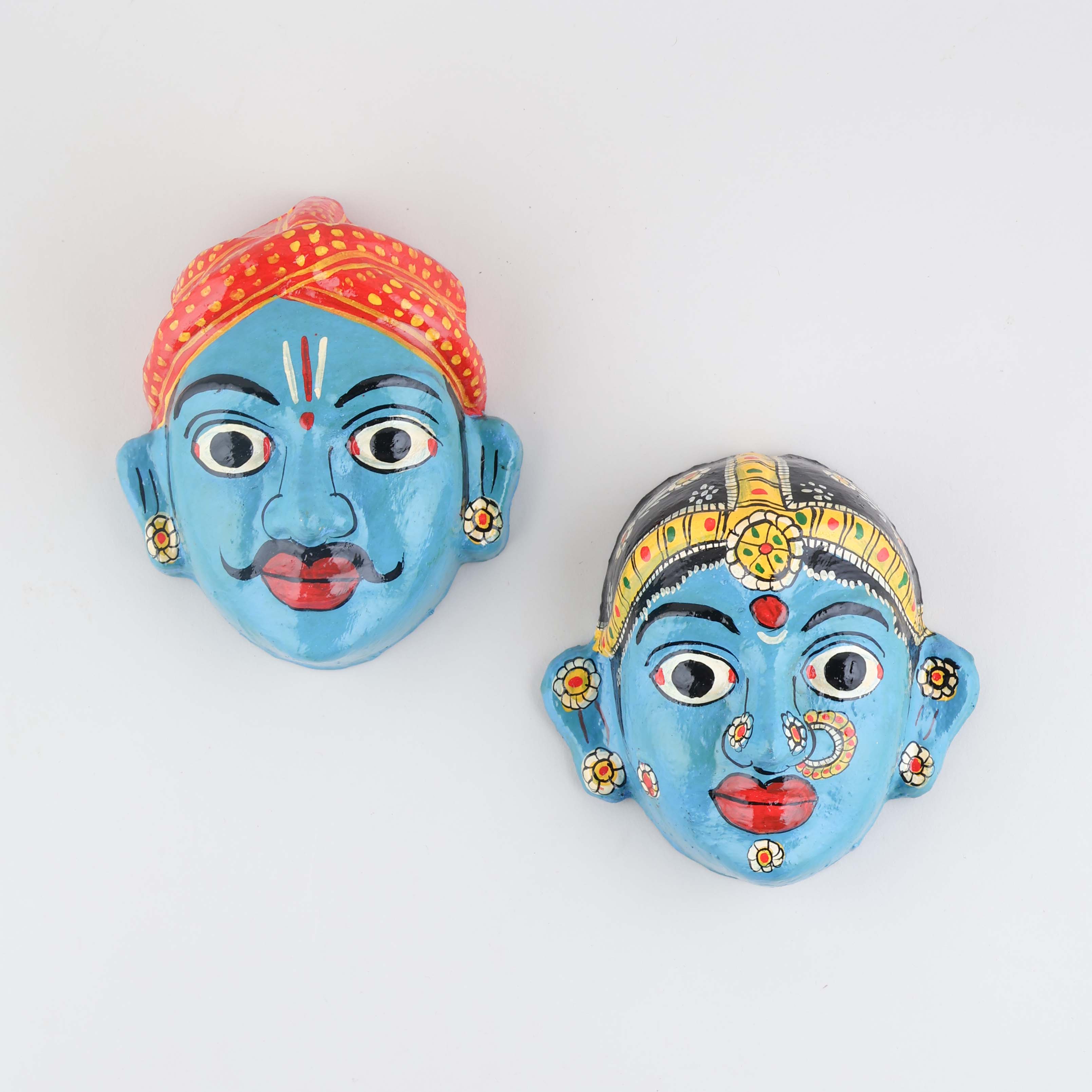 Hand-painted blue Cheriyal couple mask set crafted from papier-mache, showcasing traditional Telangana folk art and intricate decorative details on a plain background