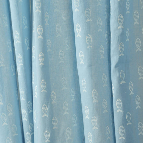 Close-up of hand block-printed fish motifs on soft blue hand dyed mulmul cotton curtain fabric.