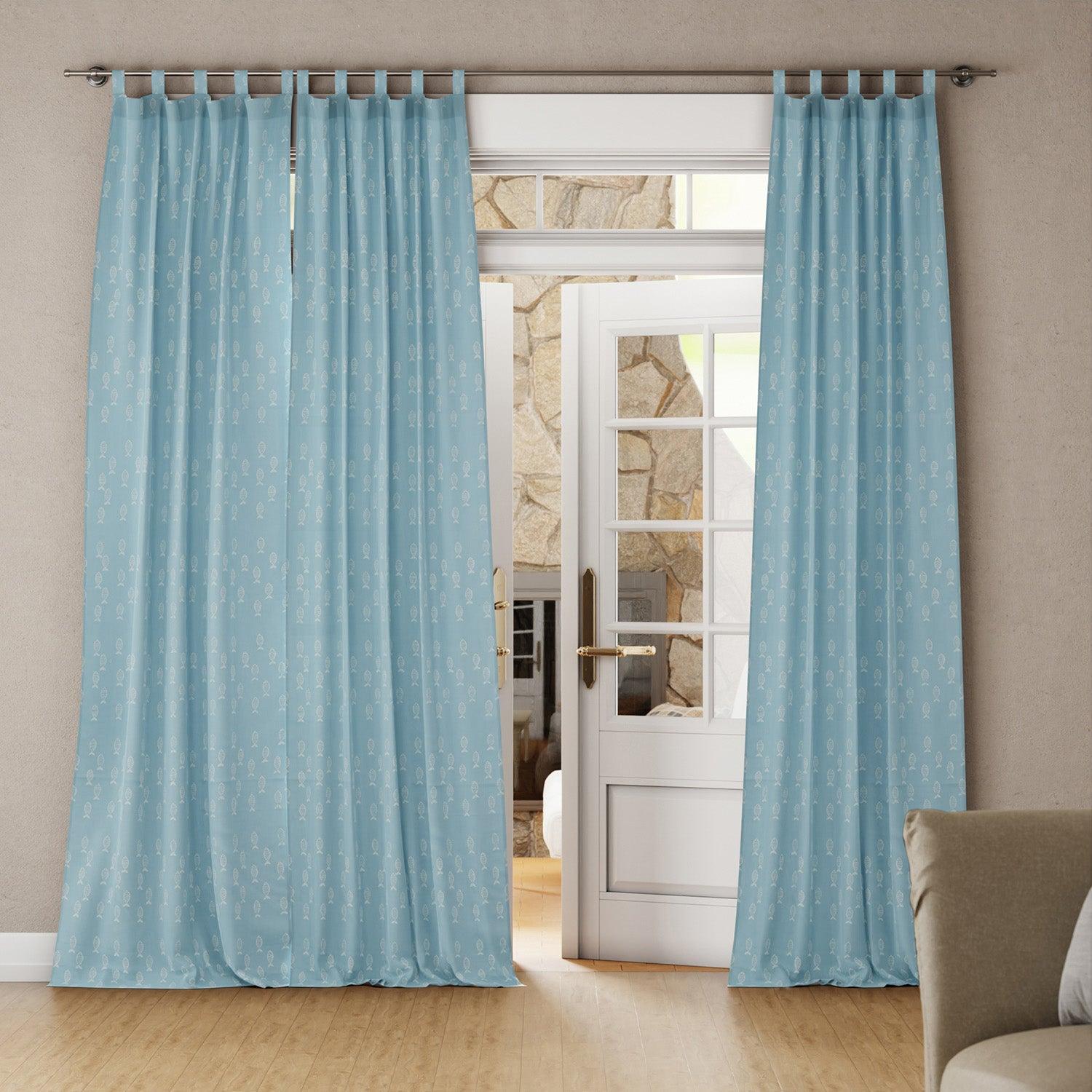 Bright living room with a blue hand-dyed mulmul cotton fish block print curtain hanging by a door