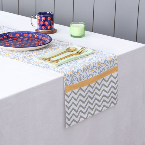 Blue floral block printed table runner styled on a dining table with coordinated table linens and dinnerware