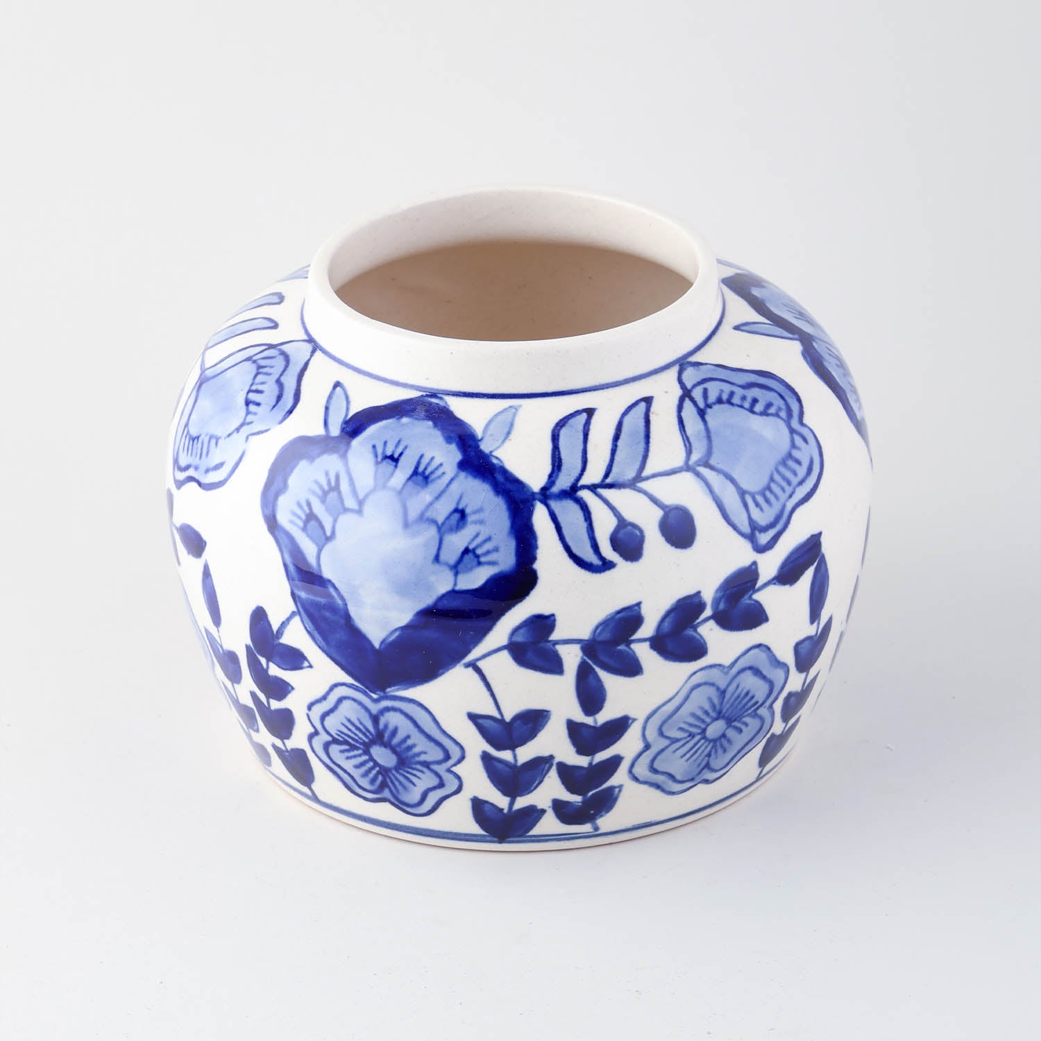 Blue floral ceramic storage jar shown with lid removed highlighting interior storage space and handcrafted finish