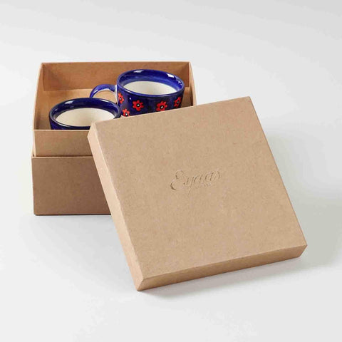 Open gift box displaying a set of two blue floral hand painted ceramic coffee mugs ready for gifting