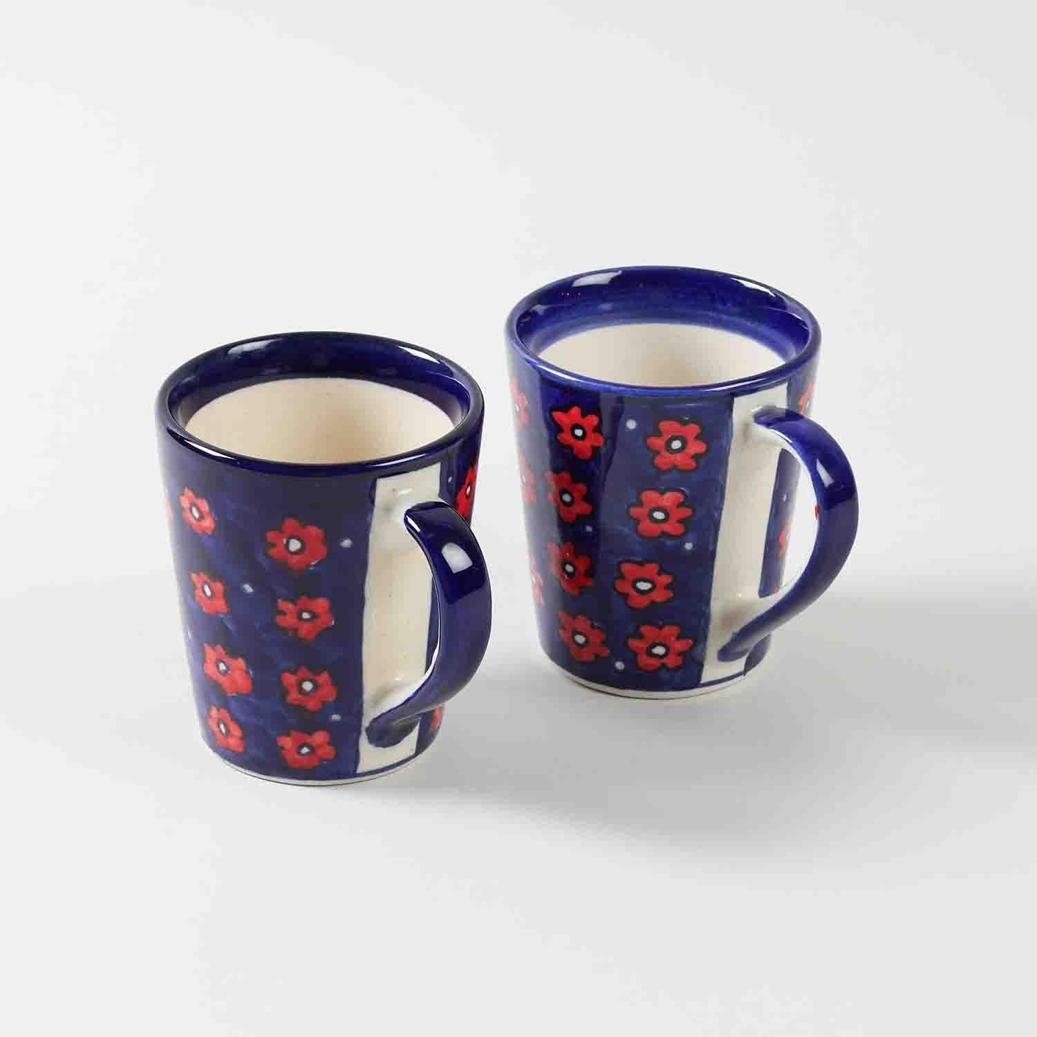 Set of two blue floral hand painted ceramic coffee mugs displayed together showcasing handcrafted artistry