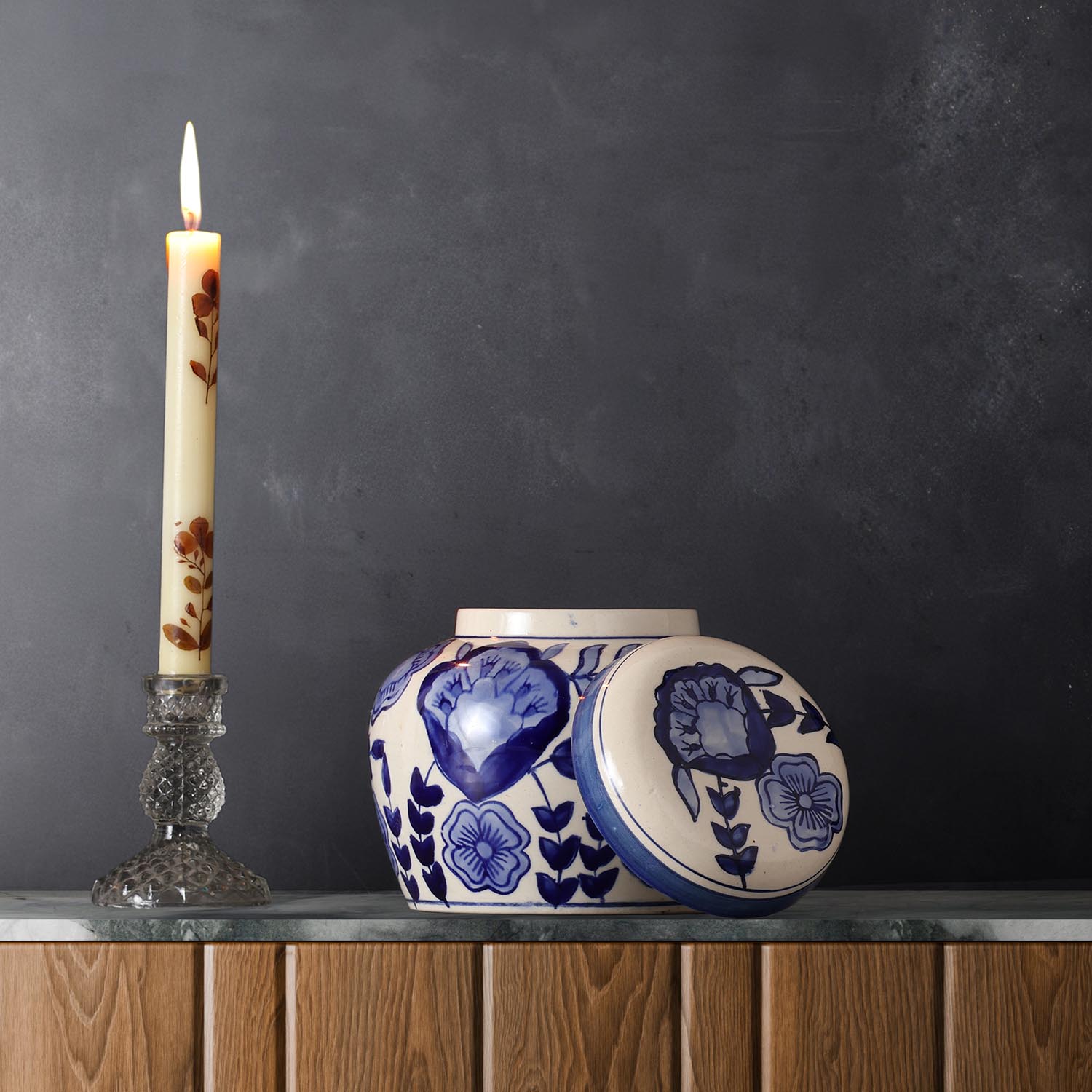 Hand-painted blue floral ceramic storage jar styled on a kitchen table for elegant countertop storage and decor