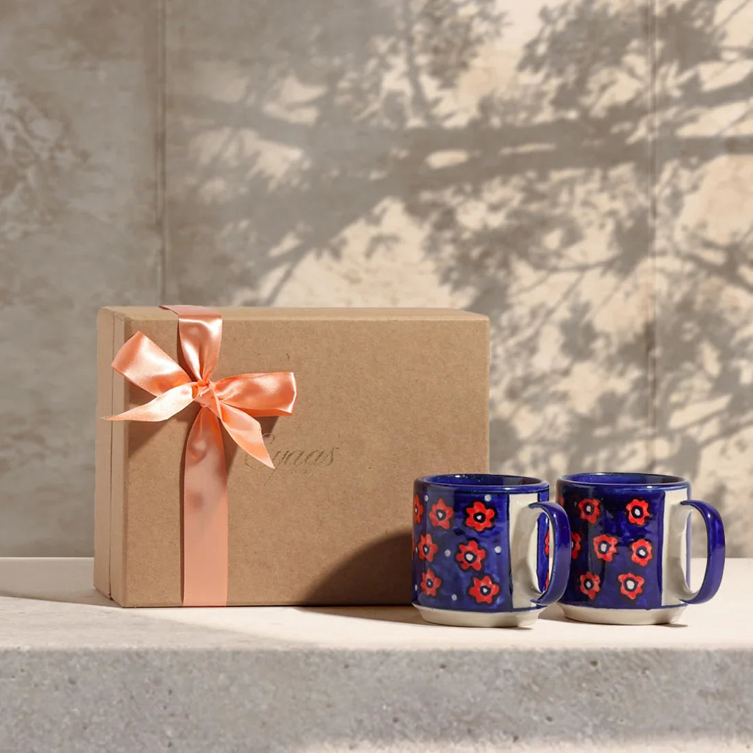 Set of two blue floral hand painted ceramic mugs styled with an elegant gift box creating a perfect gifting setup