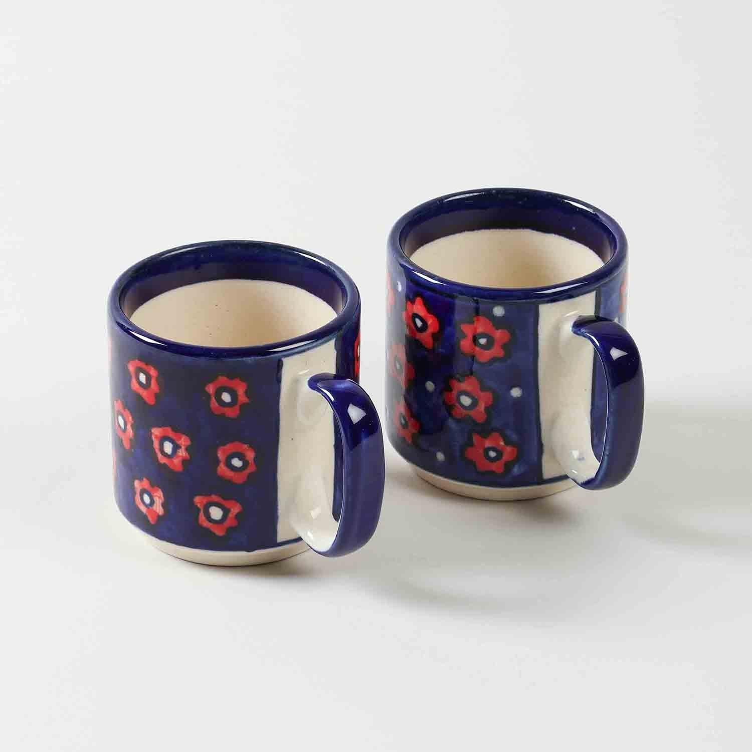 Set of two blue floral hand-painted ceramic mugs displayed together against a clean background showcasing handcrafted design and glossy finish