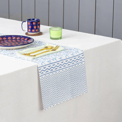 Blue lily hand block printed cotton table runner styled on a dining table with coordinated tableware and home decor accents