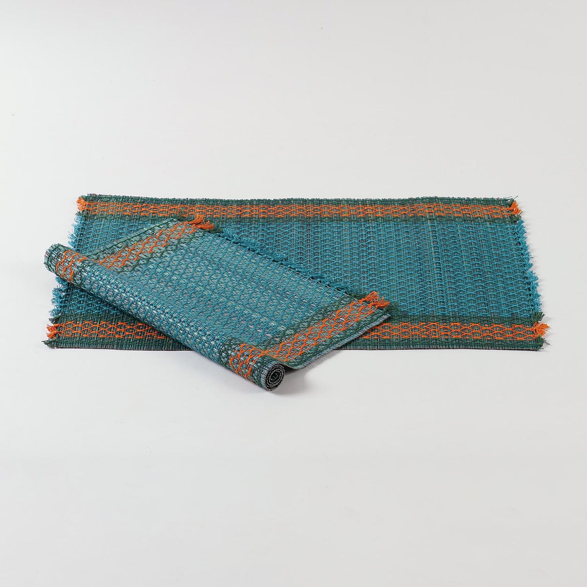 Set of 2 blue Madurkathi placemats displayed as 1 flat and 1rolled showcasing handwoven river grass texture and colourful border accents