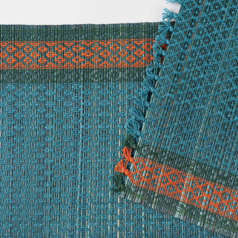 Close-up of a blue Madurkathi table runner featuring intricate handwoven patterns, natural fibre texture, and detailed border accents