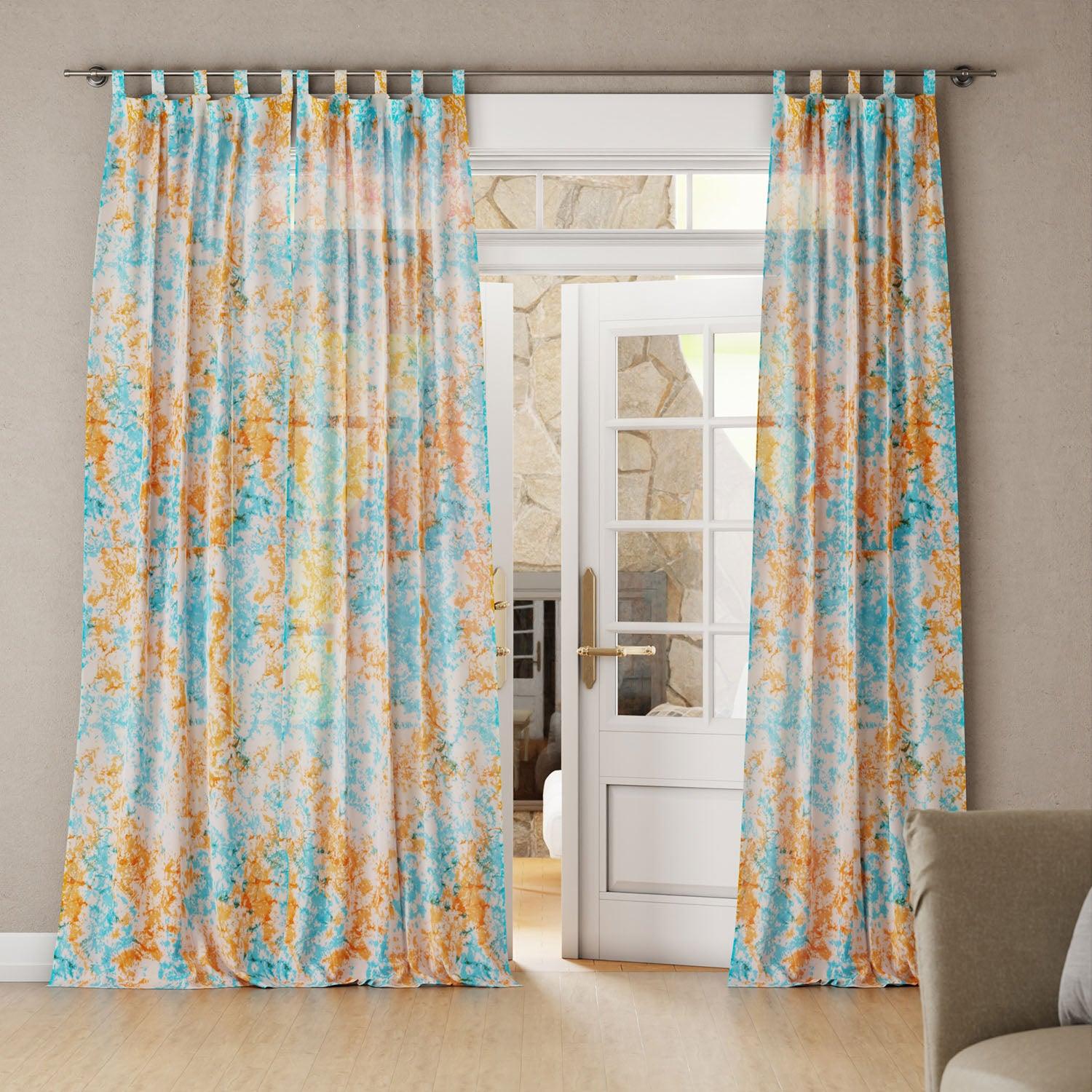 Bright living room with Blue and orange tie-dye mulmul cotton curtain hanging by a door, creating a light and airy space.