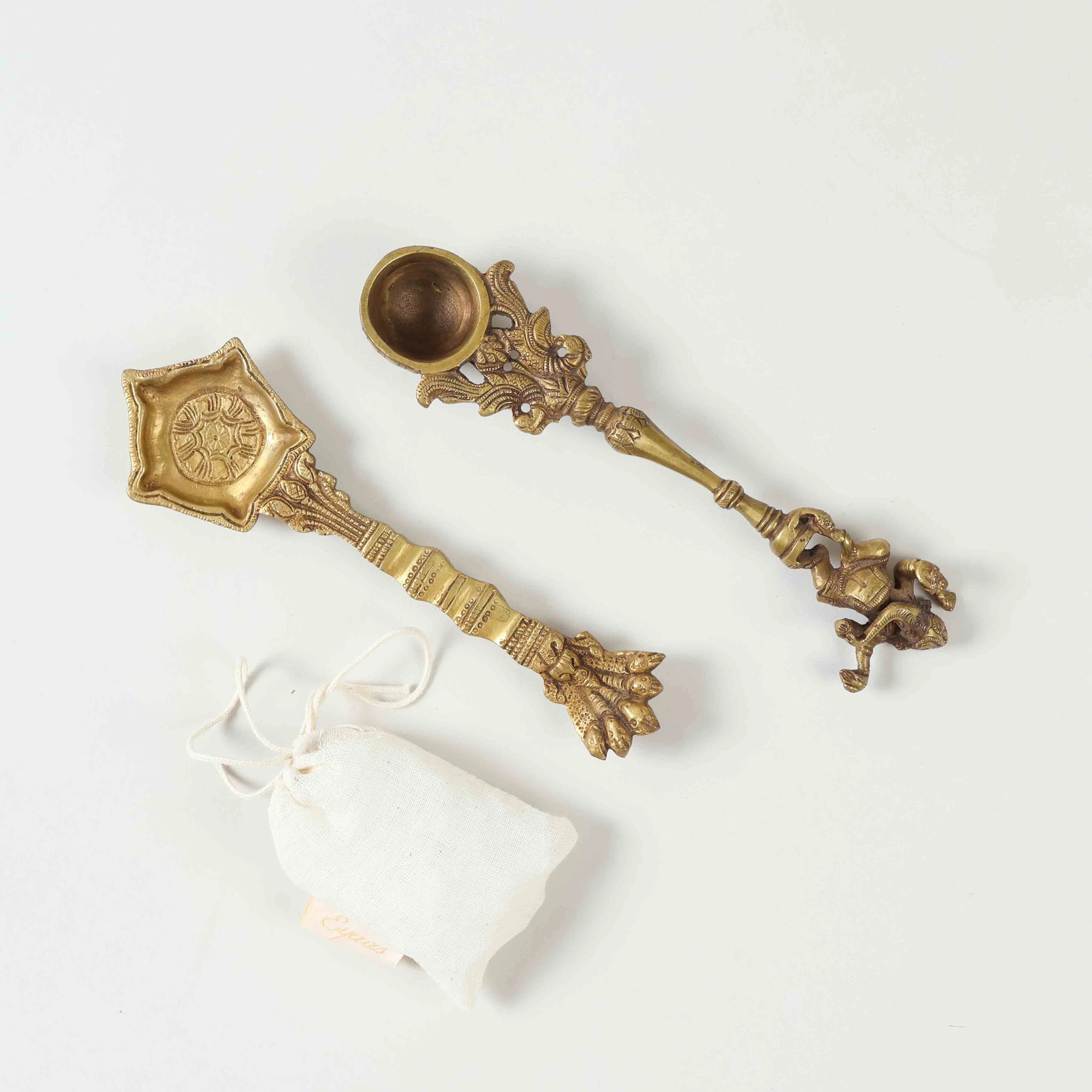Top view of a gift set featuring two handcrafted brass hawan spoons and one Kapoor packet arranged together, showcasing all three items