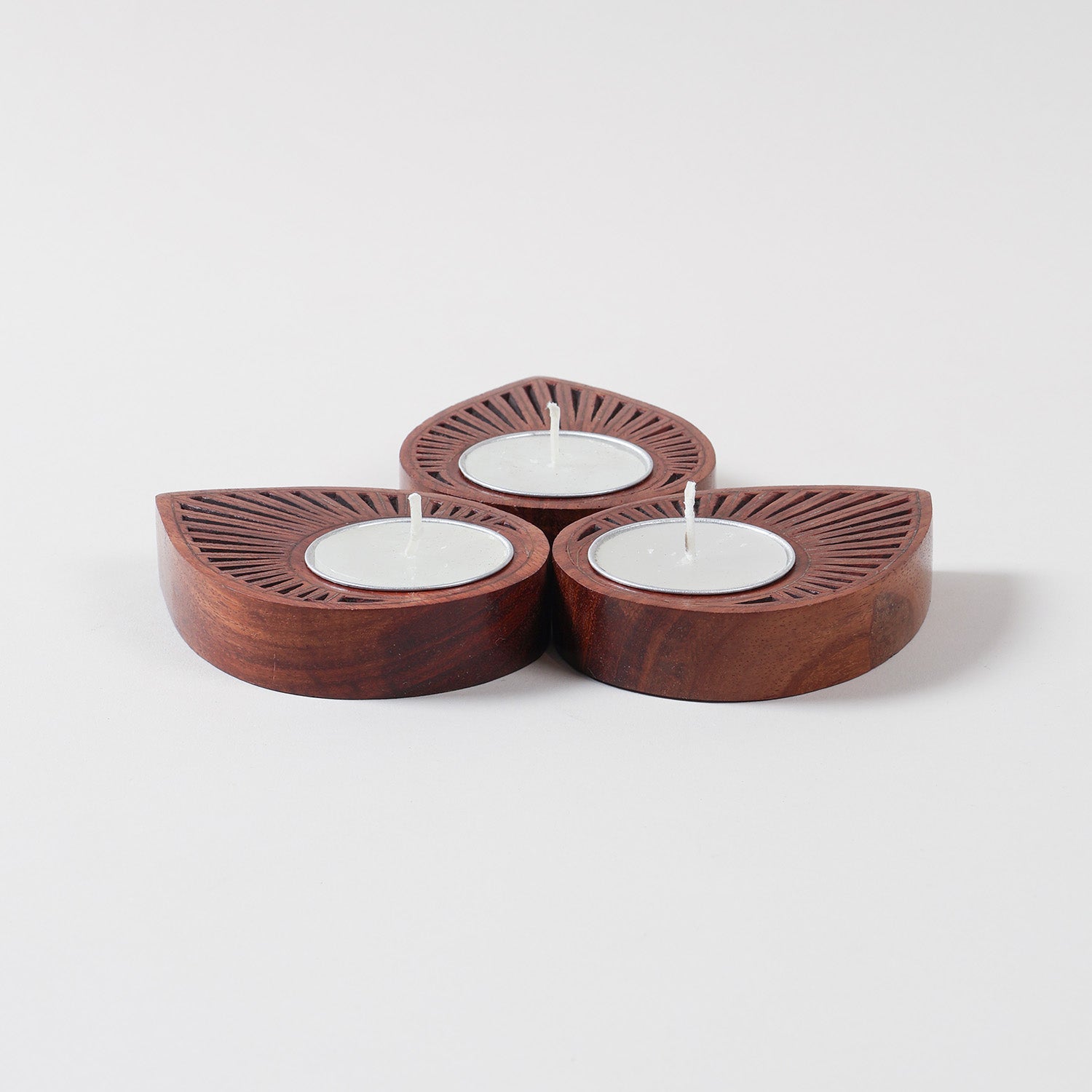 Hand carved wooden T-light holder set of 3 featuring brass inlay detailing and raindrop-shaped design on a plain background