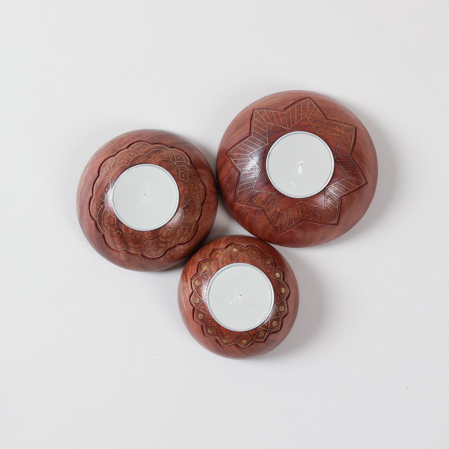  Hand carved wooden T-light holder set of 3 with brass inlay detailing, featuring star, scalloped, and lotus patterns on a plain background