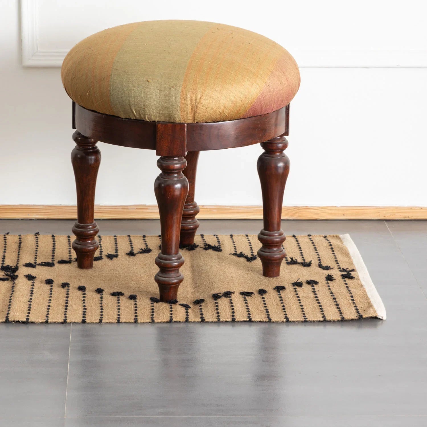 Brown and black stripe handwoven cotton jute dhurrie rug styled in an entryway, adding warmth, texture and handcrafted charm to the space