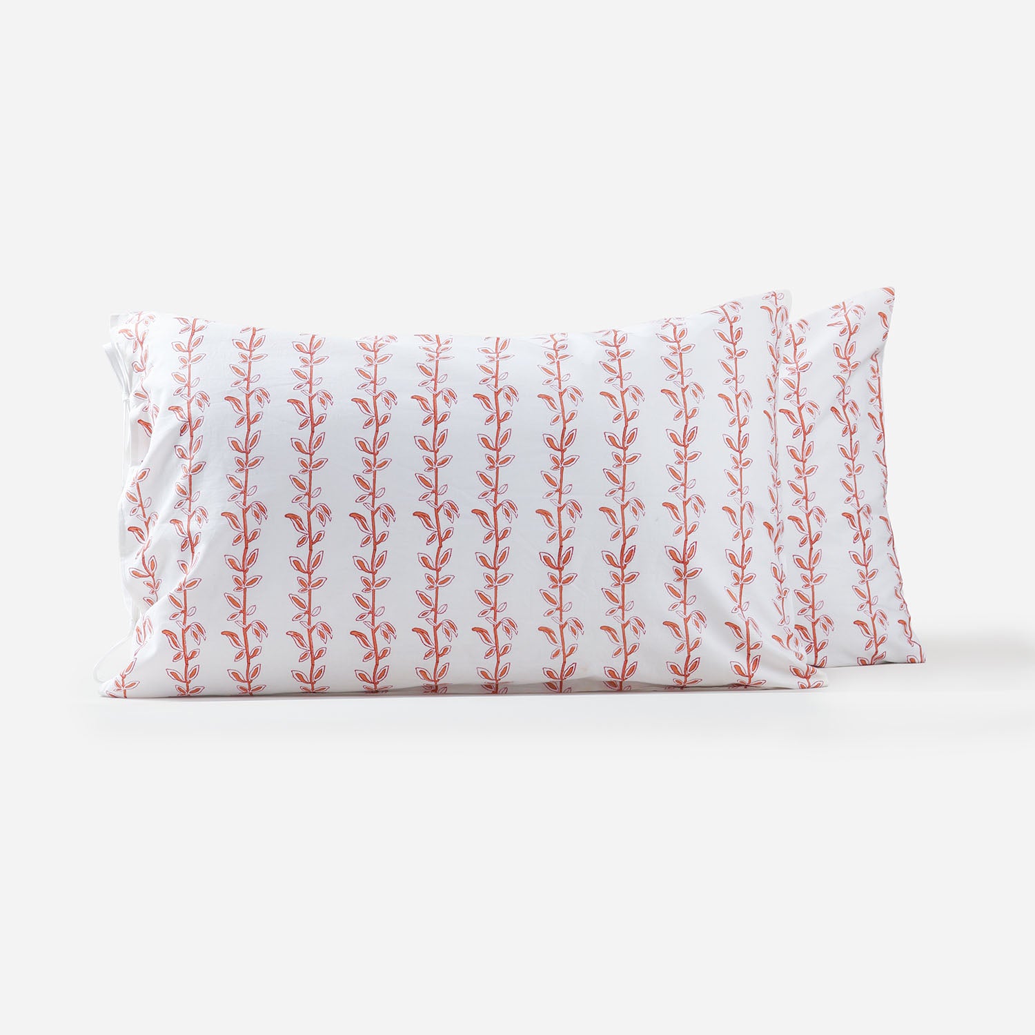 Set of two handblockprinted cotton pillow covers with brown and red climbing vine block print design on a white background, handcrafted using traditional crafts