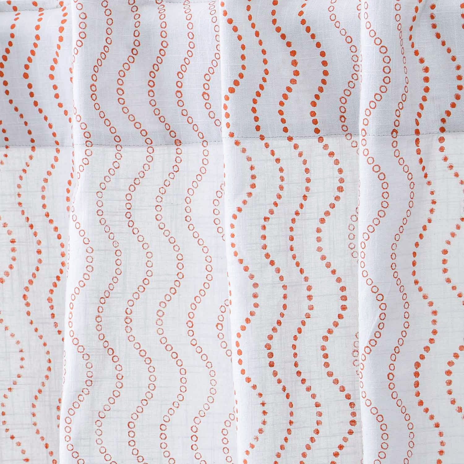 Close-up of grey cotton slub curtain fabric with a hand block printed brown wave design