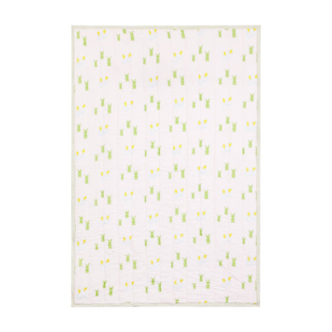 Full view of a 60x90 reversible cotton quilt featuring playful bunny and carrot motifs in pink, blue, green, and yellow tones