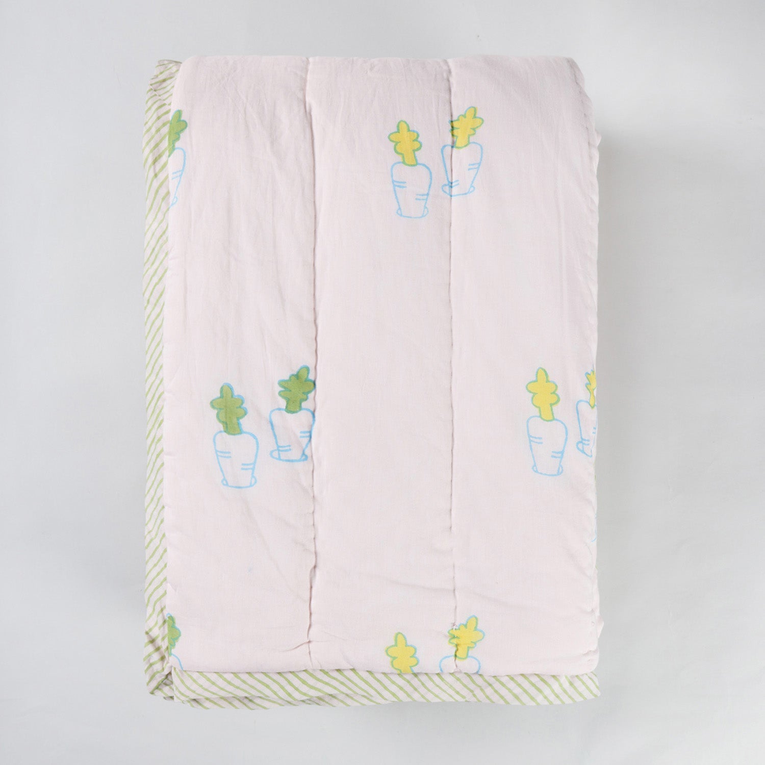 Folded hand block printed cotton quilt showcasing bunny and carrot motifs, lightweight construction, and soft cotton texture