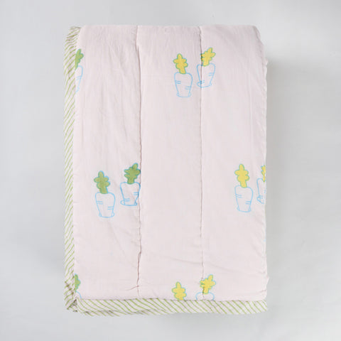 Folded hand block printed cotton quilt showcasing bunny and carrot motifs, lightweight construction, and soft cotton texture