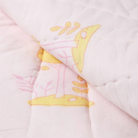 Detailed close-up of hand block printed bunny and tree motifs on a cotton quilt, showcasing artisan craftsmanship and stitching