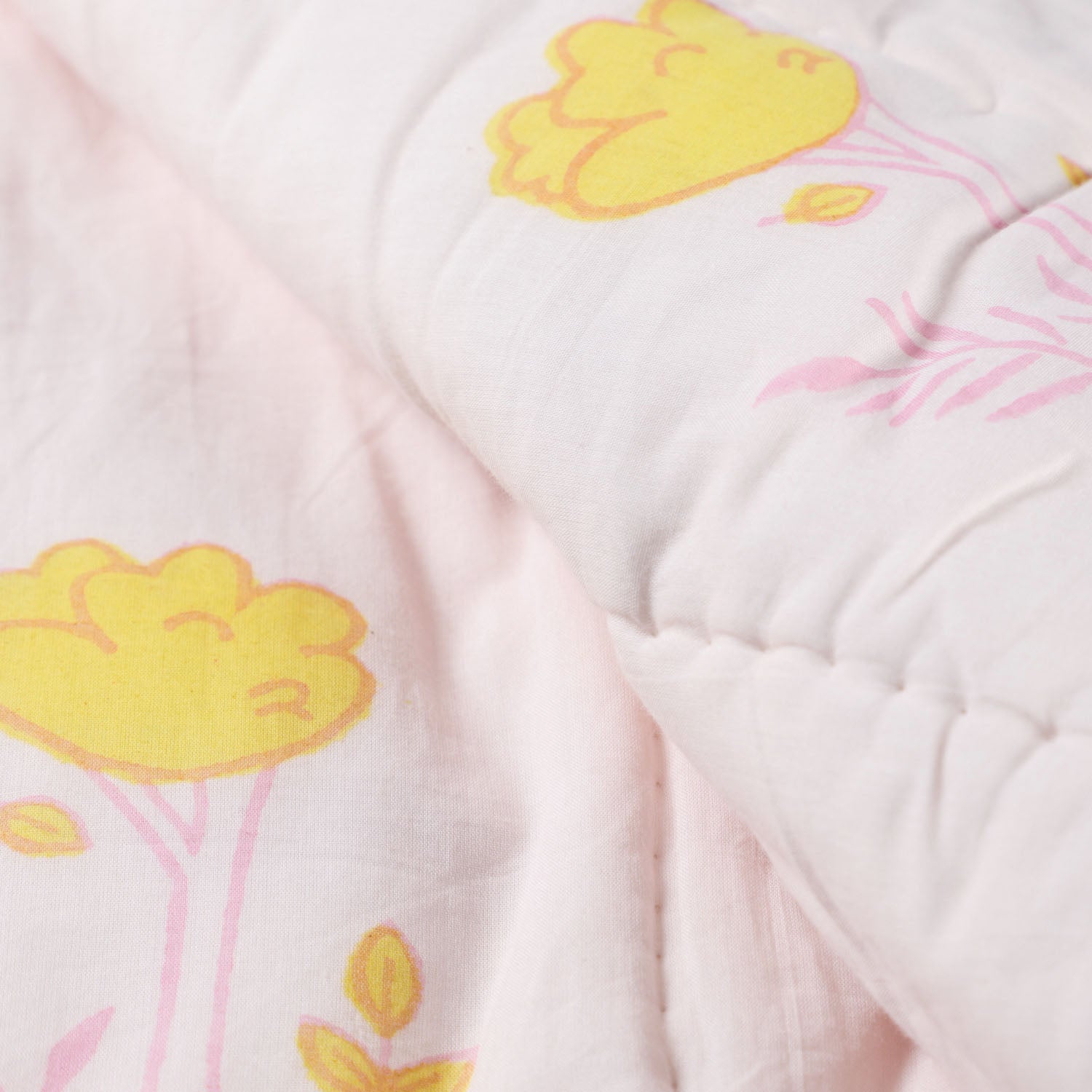 Close-up of bunny and tree block printed cotton quilt fabric highlighting handcrafted motifs, stitching details, and soft cotton texture