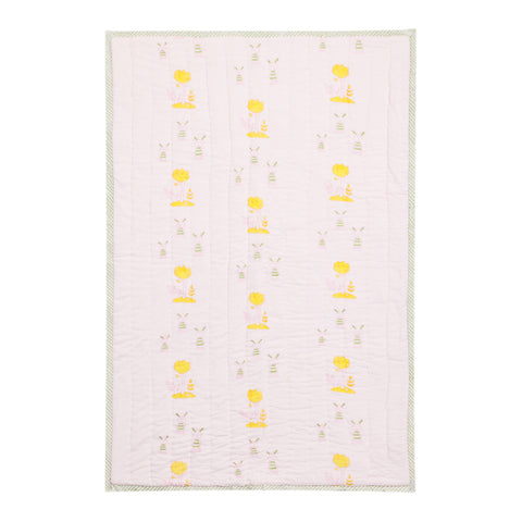 Full view of a 60x40 reversible cotton quilt featuring bunny and tree motifs in pastel shades on a light pink background