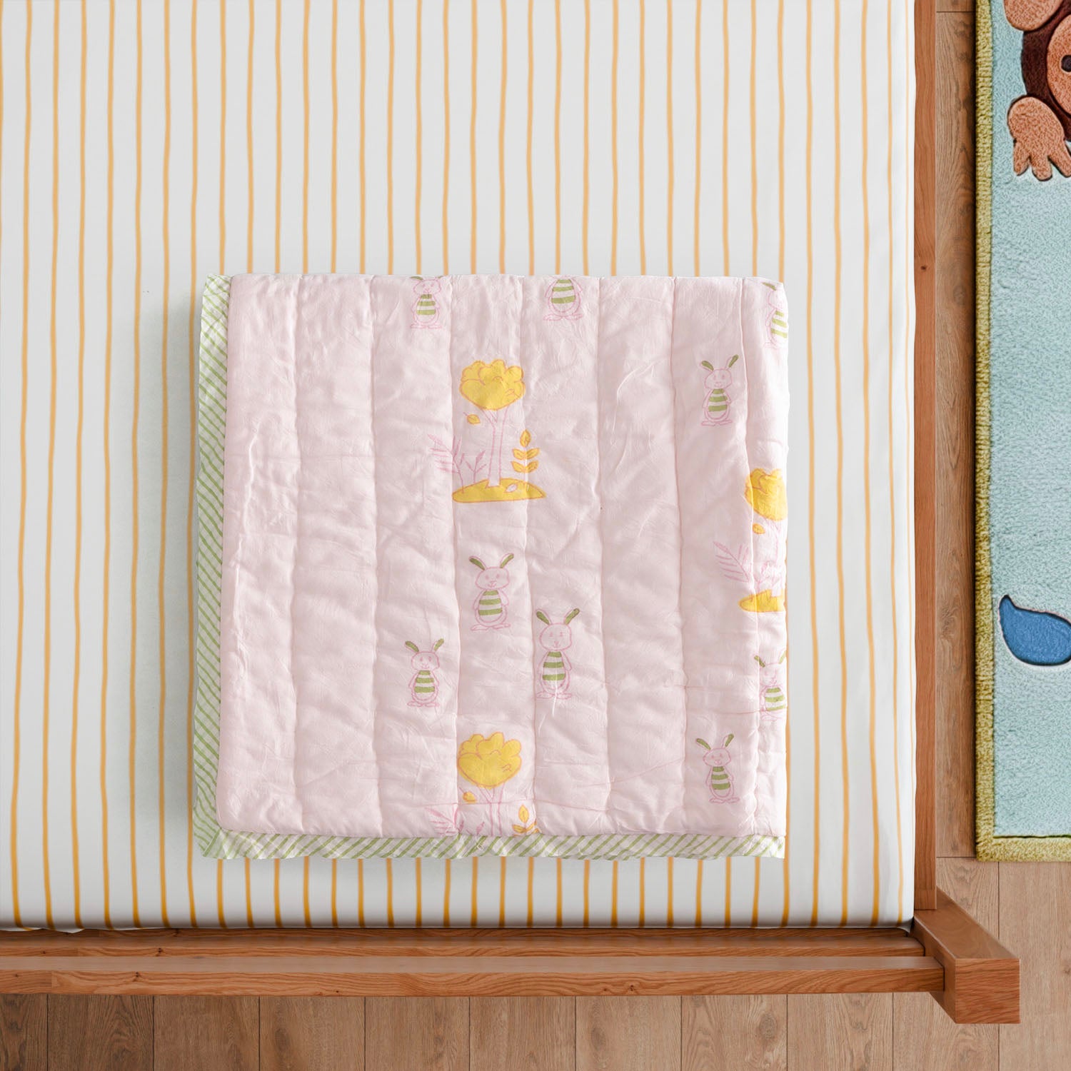 Styled close-up of a bunny and tree block printed cotton quilt highlighting breathable cotton fabric, handcrafted printing, and soft texture