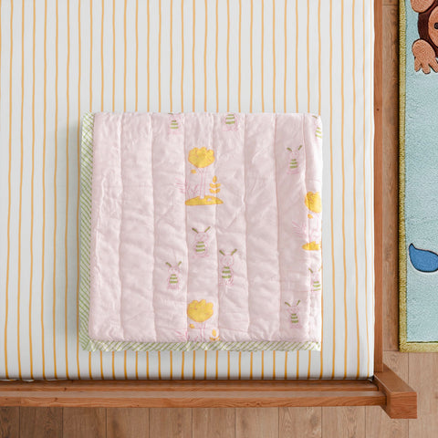 Styled close-up of a bunny and tree block printed cotton quilt highlighting breathable cotton fabric, handcrafted printing, and soft texture