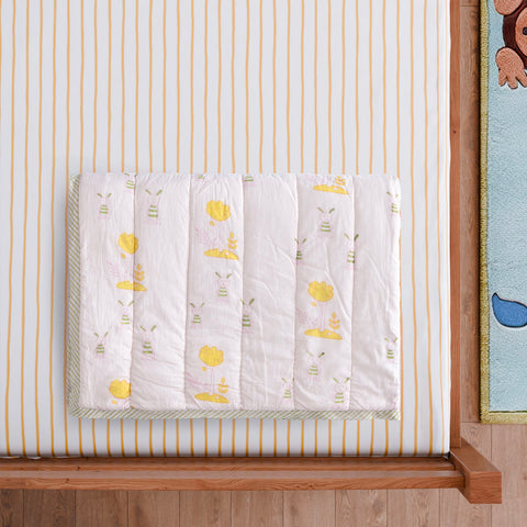  Styled close-up of a folded hand block printed cotton quilt featuring bunny and tree motifs, showcasing breathable cotton fabric and detailed artisan printing
