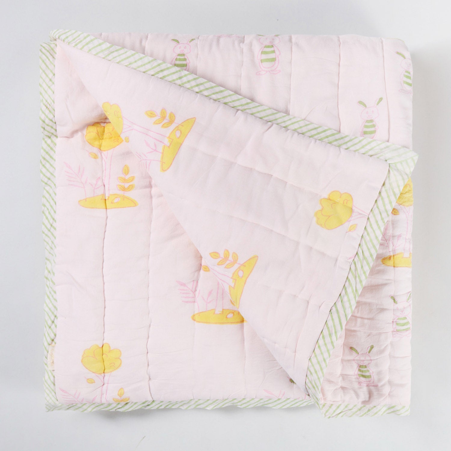 Reversible cotton quilt displaying both front and back designs with hand block printed bunny and tree motifs on soft breathable cotton