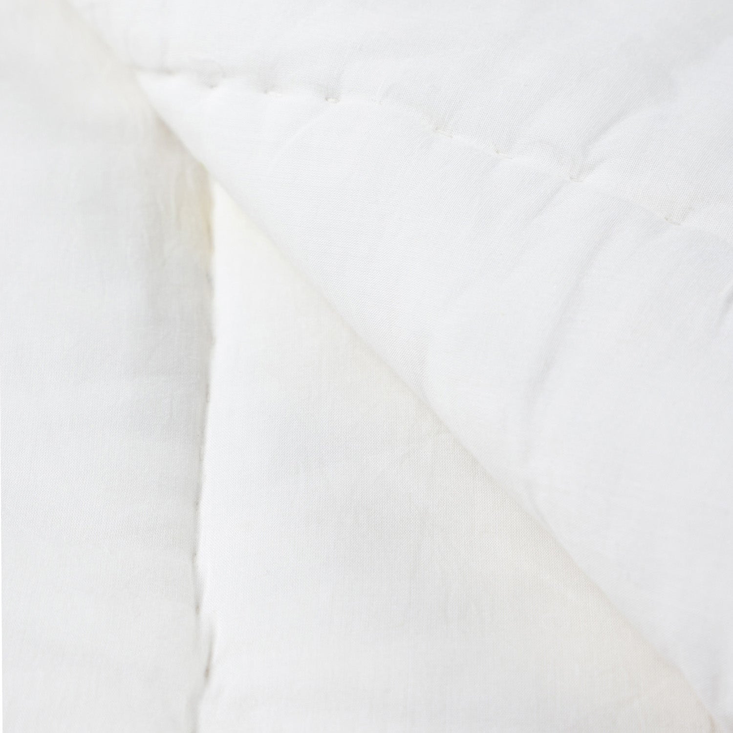 Close-up of the back side of a reversible cotton quilt featuring breathable cotton fabric