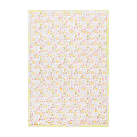 Back side of a reversible cotton quilt featuring coordinated bunny and garden block print patterns in soft pastel colours