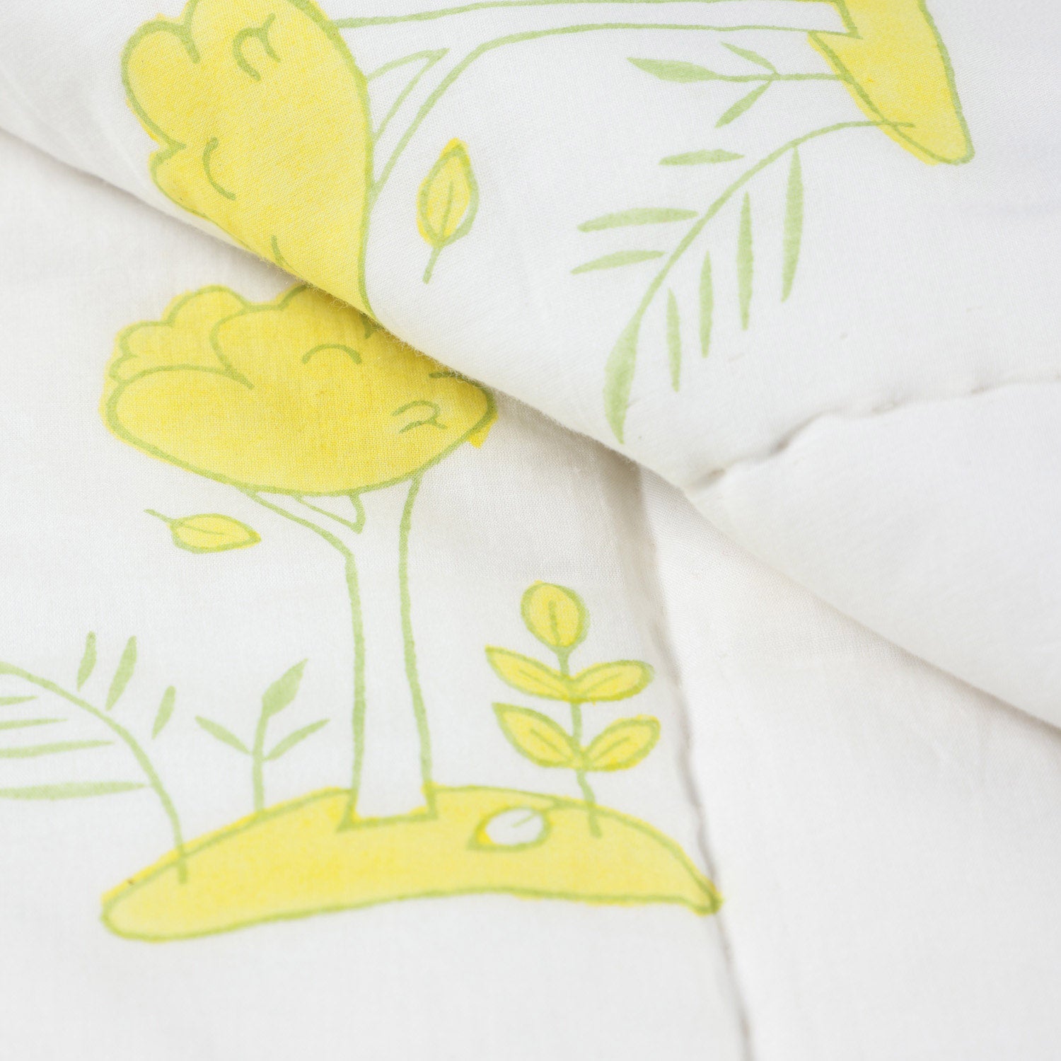 Close-up of bunny garden block printed cotton quilt fabric showing breathable cotton, stitching details, and soft multicolour prints