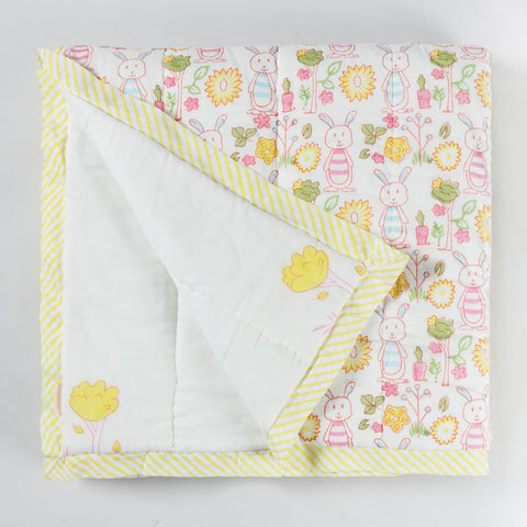 Reversible cotton quilt showing both front and back designs with bunny and garden themed hand block printed motifs