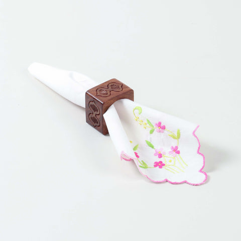 Handcrafted wooden napkin ring with butterfly engraving, holding a folded table napkin for elegant dining decor