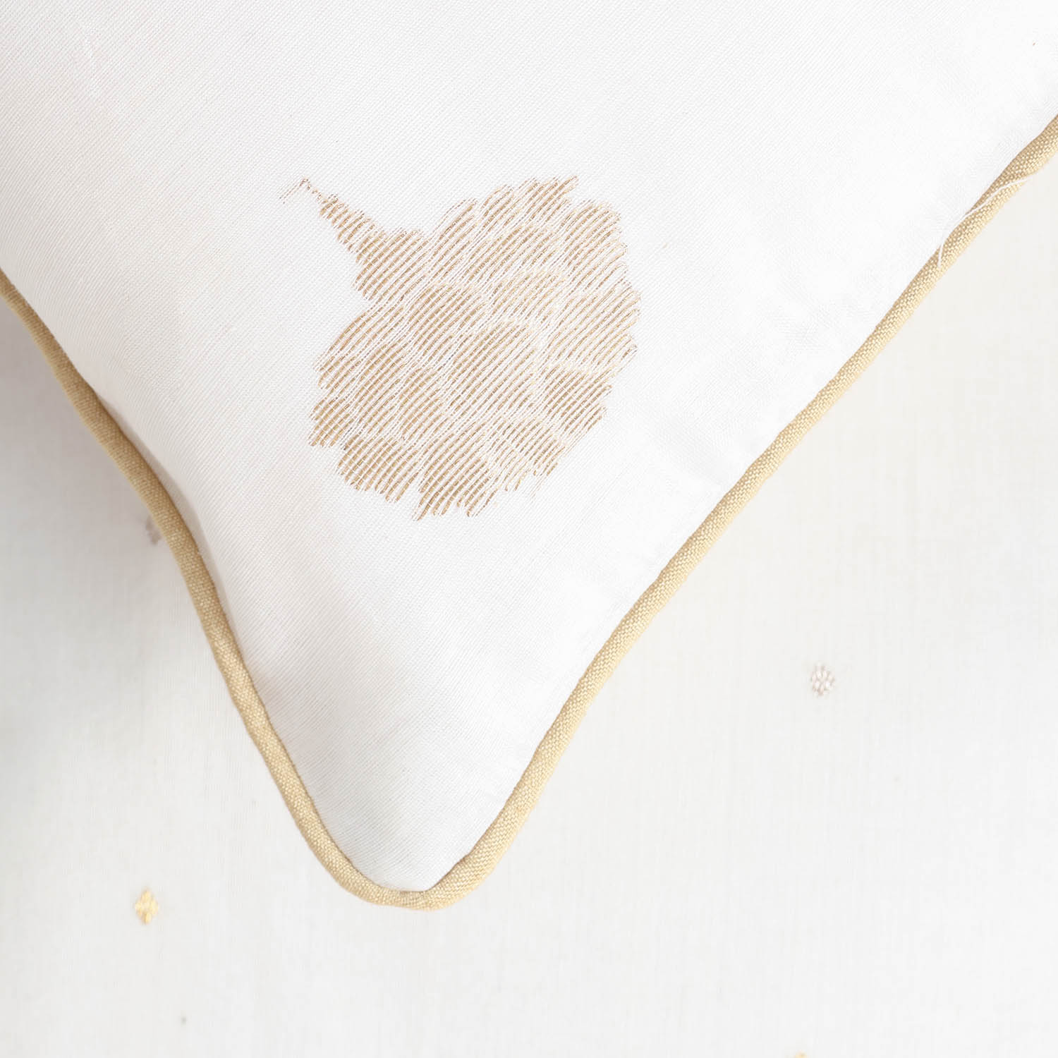 Detailed corner view of a Chanderi cushion cover featuring intricate woven tree motifs and refined finishing