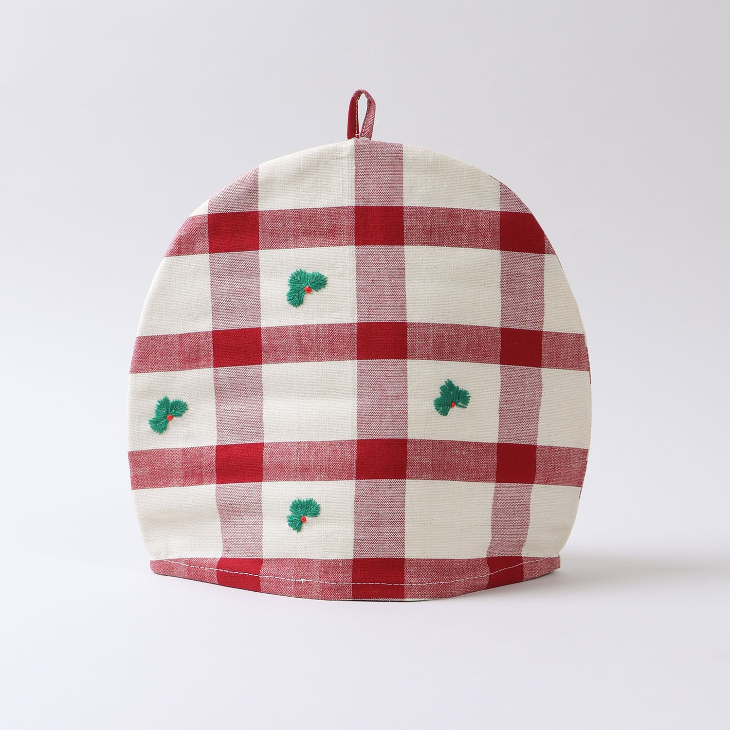 Cotton tea cozy featuring a red and off-white check pattern with green accents displayed on a plain background