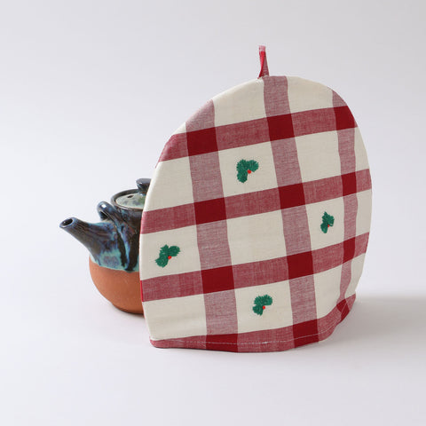 Christmas tea cozy with red and off-white check design styled on a holiday tea table, creating a warm and festive atmosphere