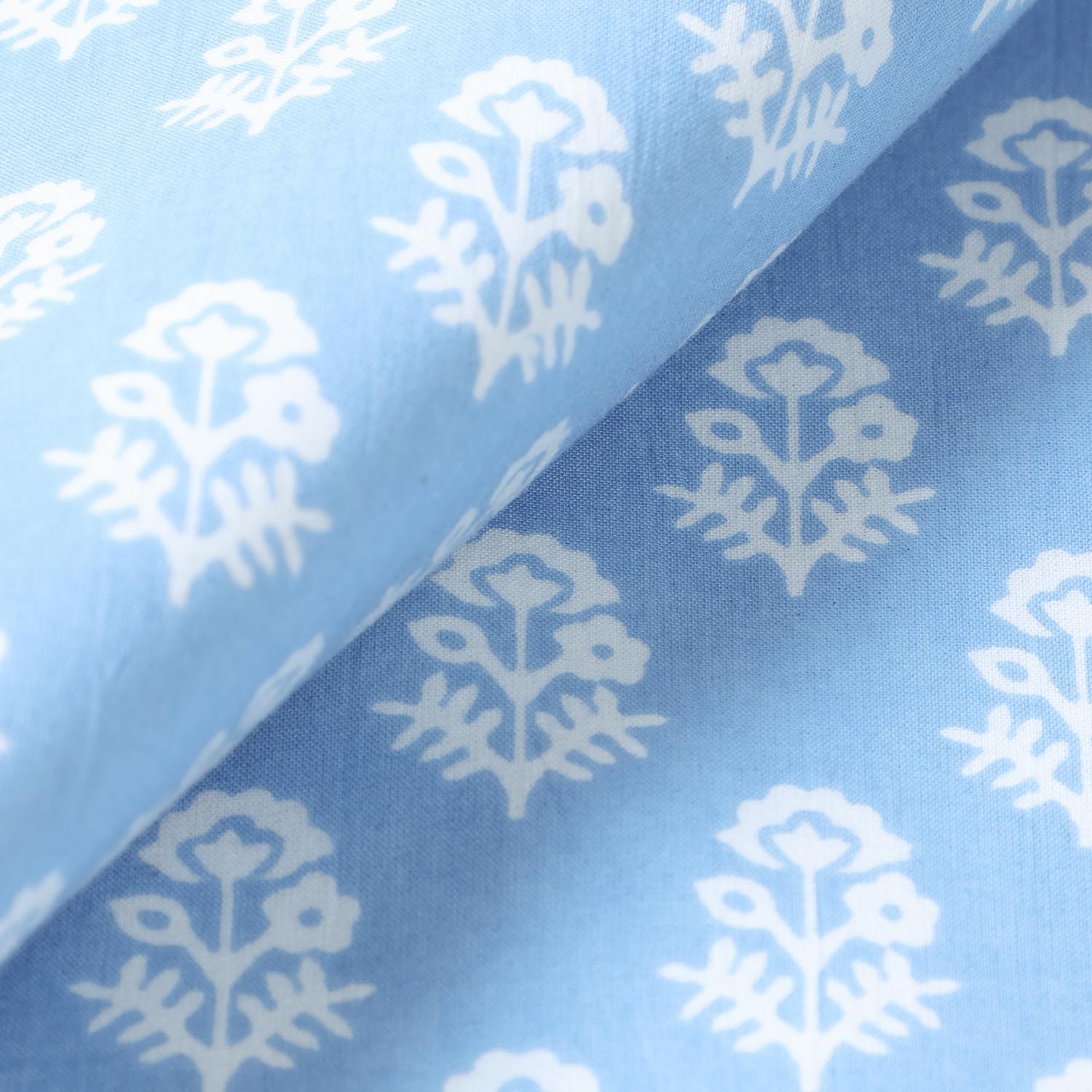 Close-up of white Christmas-inspired block printed motifs on a blue cotton placemat showcasing traditional Indian craftsmanship