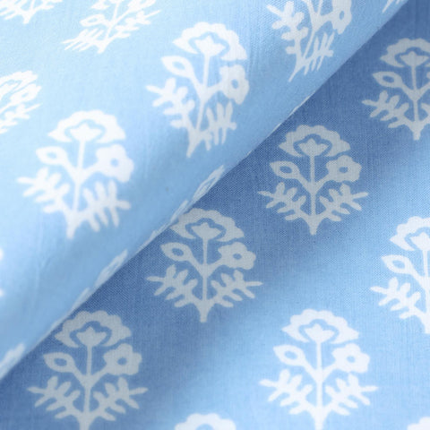 Close-up of white Christmas-inspired block printed motifs on a blue cotton placemat showcasing traditional Indian craftsmanship