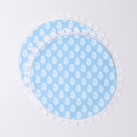 Set of 2 round cotton placemats featuring white block printed Christmas motifs on a blue base with decorative lace edging displayed on a plain background