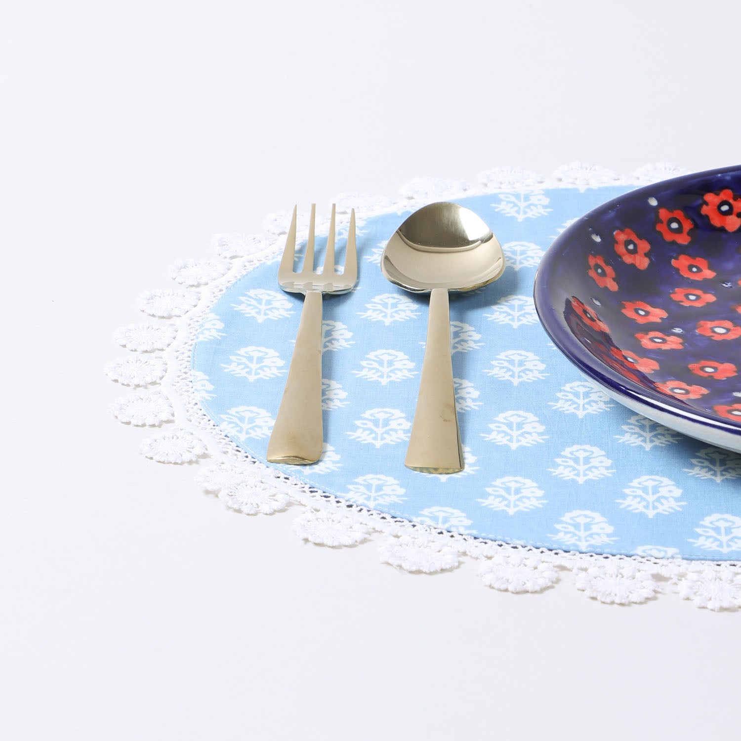 Handmade Christmas placemat arranged with dinnerware on a festive dining table creating a cheerful holiday table setting