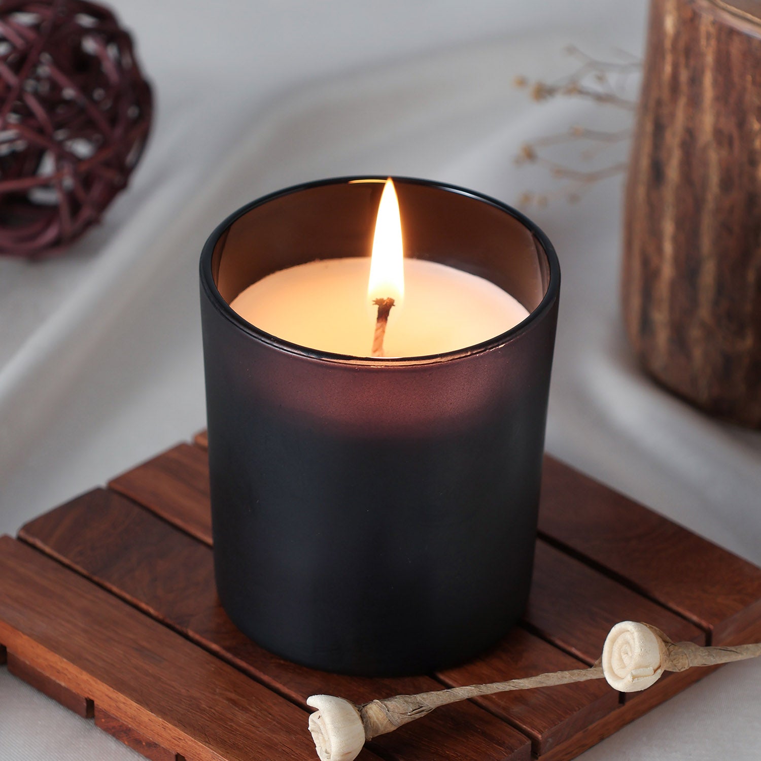 Coffee scented soy wax candle glowing warmly in a glass jar creating a cosy ambience