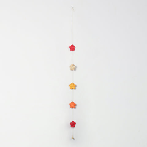 Red, yellow, orange, and natural beige flowers on a bamboo hanging