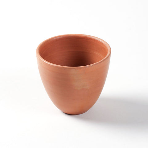 Close-up of a handthrown conical terracotta kulhad cup highlighting its handcrafted finish.