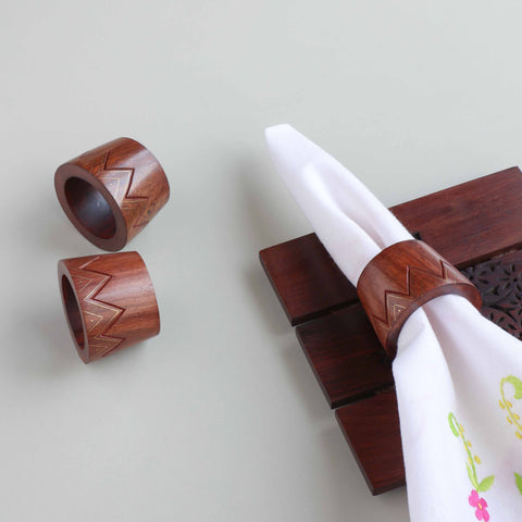 Conical wooden napkin rings with brass inlay styled on a dining table for elegant table setting decor