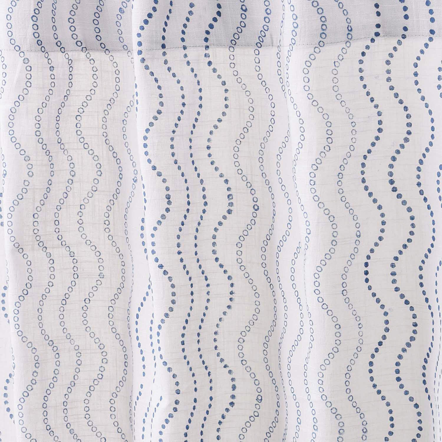 Close-up of cotton slub curtain fabric featuring a blue wave hand block printed design.