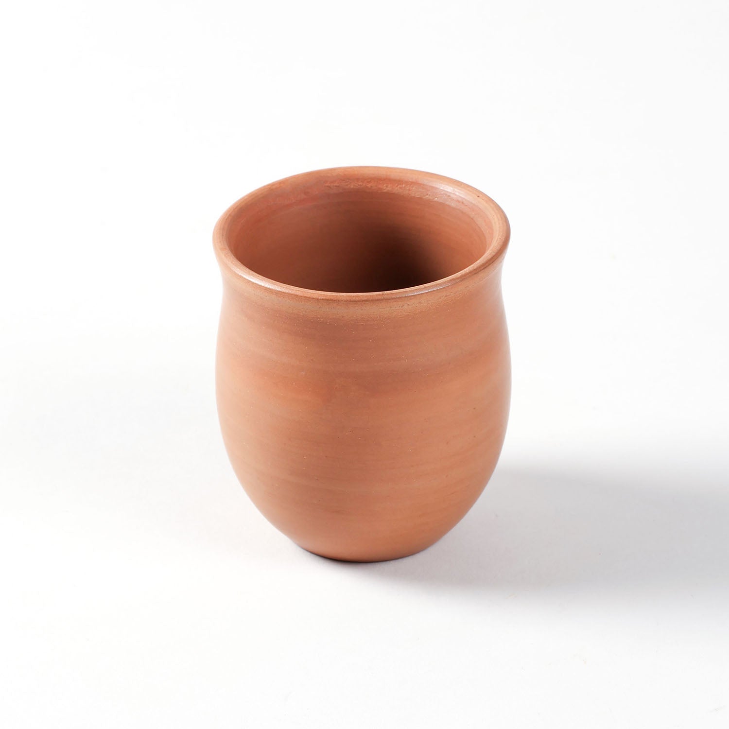 Close-up of a hand-thrown terracotta kulhad cup with a smooth curved design