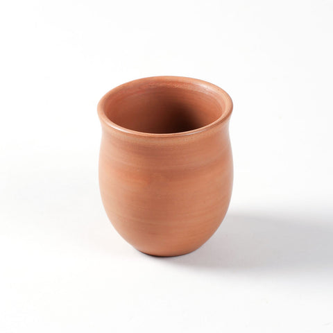 Close-up of a hand-thrown terracotta kulhad cup with a smooth curved design